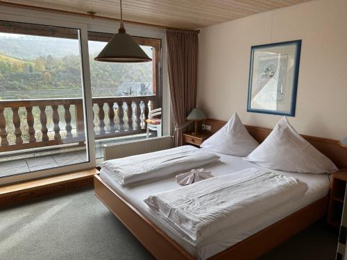 a bedroom with a large bed and a balcony at Mike‘s Mosel Lodge in Treis-Karden