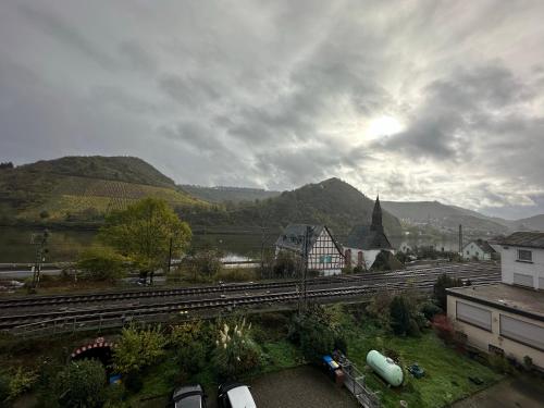 a view of a town with mountains and a train track at Mike‘s Mosel Lodge in Treis-Karden