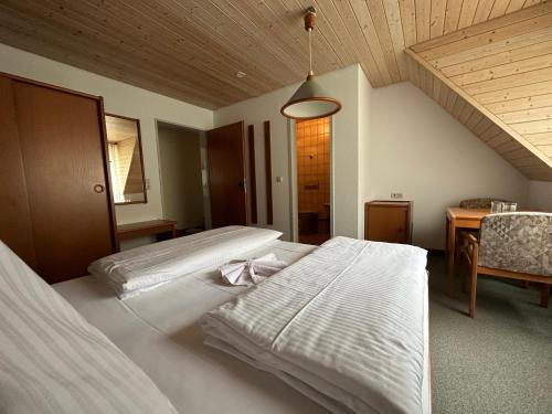 a hotel room with two beds and a table and a table at Mike‘s Mosel Lodge in Treis-Karden