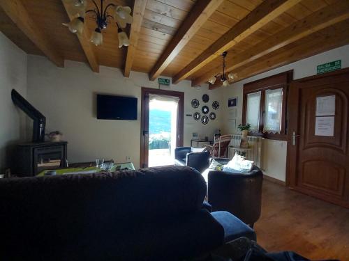 una sala de estar con sofás y techo de madera. en Casa Rural El Mirador de Villaverde, en Con