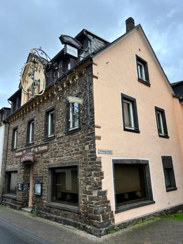 ein Gebäude mit einer Uhr auf der Seite in der Unterkunft Mike‘s Mosel Lodge in Treis-Karden