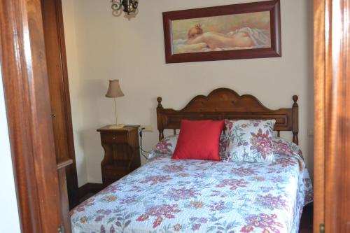 1 dormitorio con 1 cama con almohada roja en Coqueto Duplex en Vilagarcía de Arousa centro, en Vilagarcía de Arousa