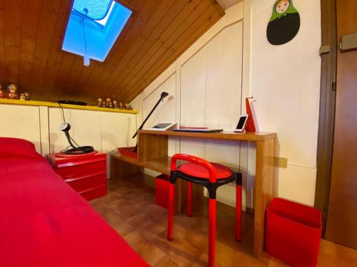 1 dormitorio con escritorio y taburete rojo en Matrioska House B&B, en Imola