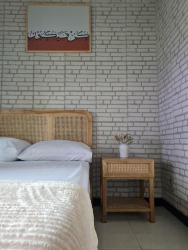 a bedroom with a bed and a side table at El jenna syariah villas in Tjolomadu