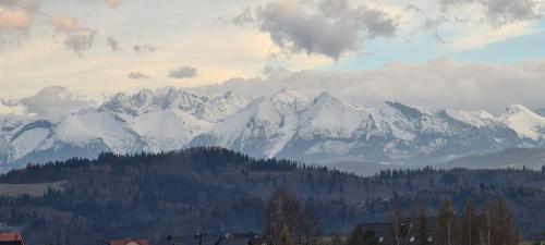 a mountain range with snow covered mountains in the distance at Domek pod Wiśnią in Mizerna