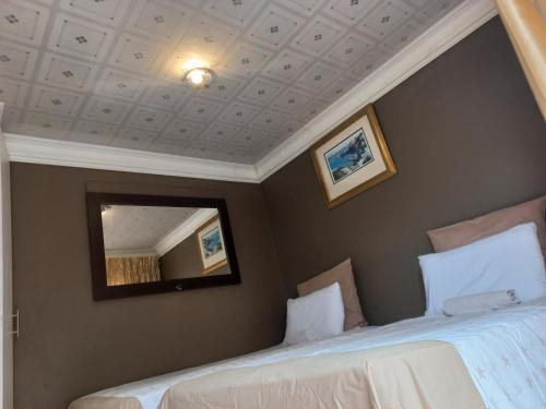 a bedroom with two beds and a mirror at sediba guest house in Krugersdorp