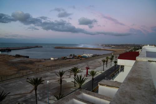 a view of a beach with palm trees and the ocean at PUERTO MARINA ASILAH in Asilah
