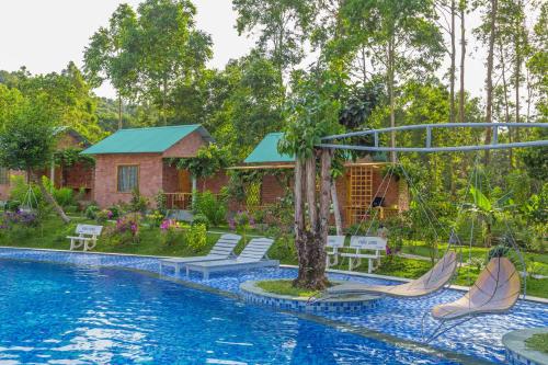 a swimming pool with chairs and a house at Sim Bungalow in Phu Quoc