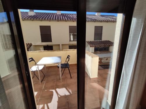 Habitación con vistas a un balcón con mesa y sillas. en Casa Carla vute-22-056, en Valdelinares