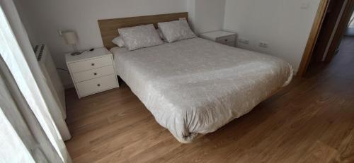 um quarto com uma cama e piso em madeira em Casa Carla vute-22-056 em Valdelinares