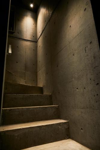 a concrete wall with stairs in a room at Boutique Sauna ARCH in Tokyo