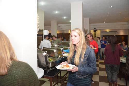 a woman holding a plate of food in a restaurant at La Maison Hotel in Wadi Musa
