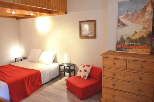 - une chambre avec un lit, une commode et une chaise dans l'établissement Granges 32 - Beau Duplex spacieux, au pied des pistes Domaine Alpe d'Huez, à Villard-Reculas