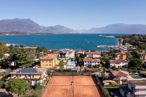 een stad met een tennisbaan voor het water bij La Quiete Park Hotel in Manerba del Garda