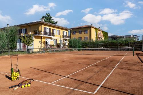una raqueta de tenis y pelotas en una pista de tenis en La Quiete Park Hotel, en Manerba del Garda