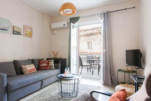 a living room with a couch and a table at OpenAir HOT TUB/Big Balcony/Great Boutique Apt in Athens