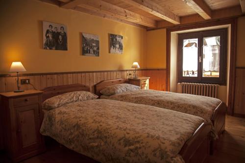 una camera con due letti e una finestra di Casa Smitt ad Alagna Valsesia