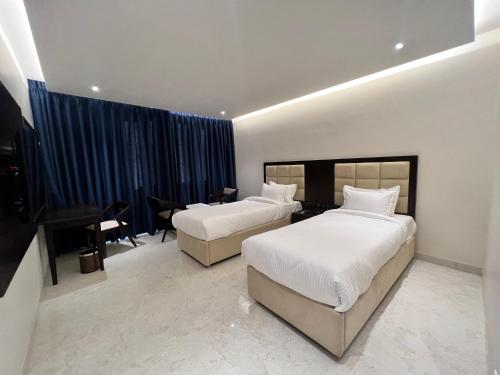 a hotel room with two beds and a piano at Mayur Belgaum Presidency Hotel & Spa in Belgaum