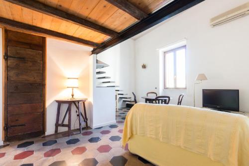 ローマにあるSunny Apartment Navona Squareのベッド1台、テレビ、階段が備わる客室です。