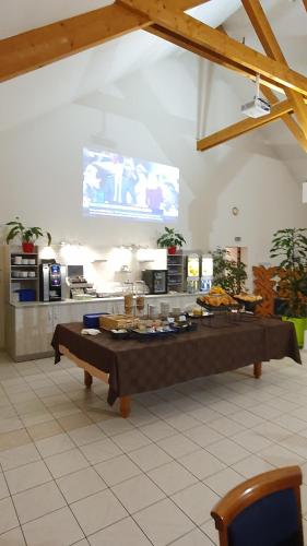 a large kitchen with a table with food on it at Logis Hotel Restaurant de l'Abbaye in Ferrières