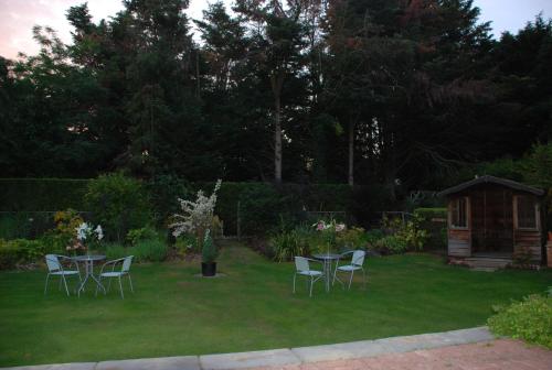 a yard with chairs and a table and a gazebo at Beech House Hotel in Reading