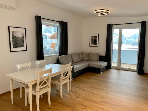 uma sala de estar com uma mesa e cadeiras e um sofá em Apartments Oliver, Axams em Innsbruck