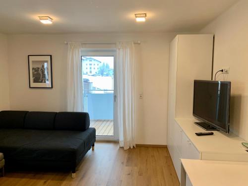 a living room with a couch and a television at Apartments Oliver, Axams in Innsbruck