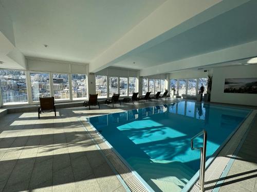 a large swimming pool in a building with windows at Panorama & SPA Apartment Kaiser Franz Josef I im Schillerhof in Bad Gastein
