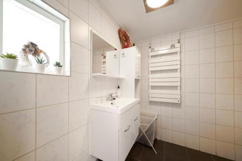 a white bathroom with a sink and a window at B B Huize Hooijer in Beekbergen
