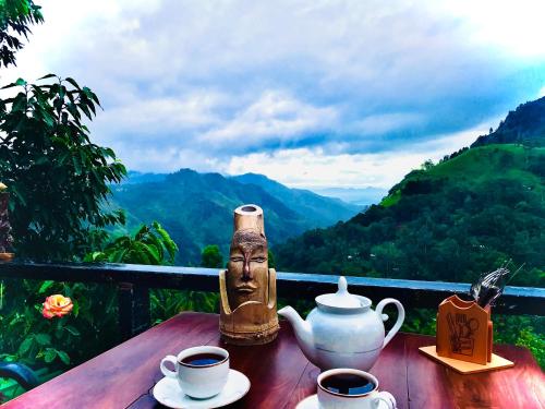 a table with cups of tea and a statue on it at Ella HIDE VIEW in Ella