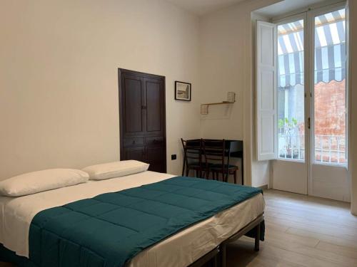 a bedroom with a bed and a table and a window at FondacOlivella in Naples