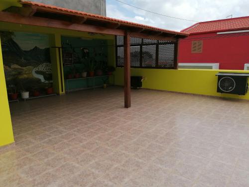 un patio con un edificio rojo y amarillo en Residencial Chez Flor, en Porto Novo