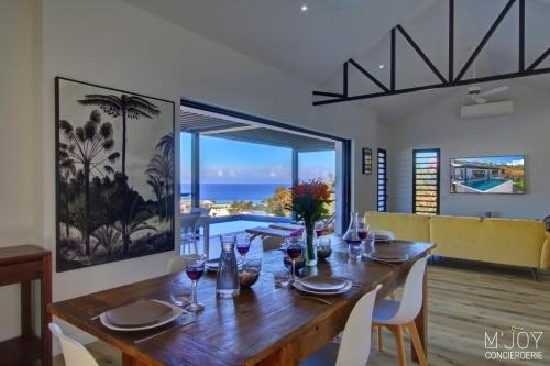 uma sala de jantar com uma mesa e vista para o oceano em Villa Azur Saint-Gilles - La Réunion - Seaview, Pool, Beach & BBQ! em Saint-Gilles-les-Bains