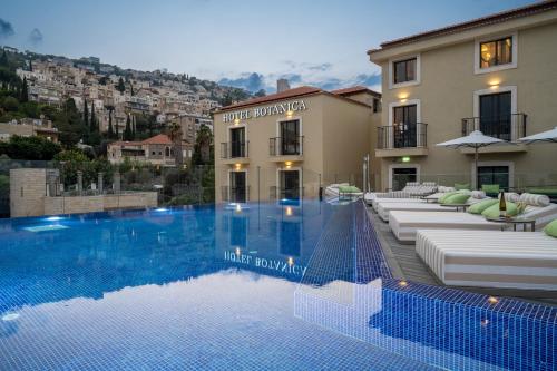 un hotel con piscina frente a un edificio en Hotel Botanica- Limited Edition By Fattal, en Haifa
