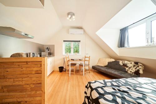 a bedroom with a bed and a kitchen with a table at B B Huize Hooijer in Beekbergen