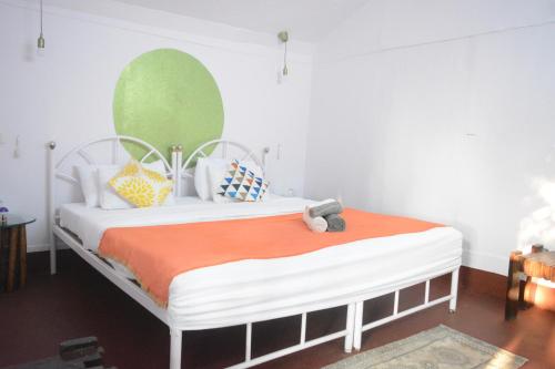 1 dormitorio con 1 cama con manta naranja en GoYm Resort, en Arambol