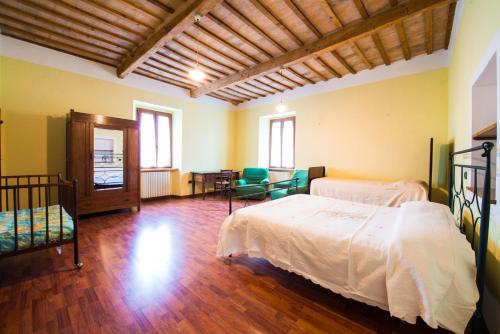 a bedroom with two beds and a table and chairs at Villa degli Orti in Acqualagna
