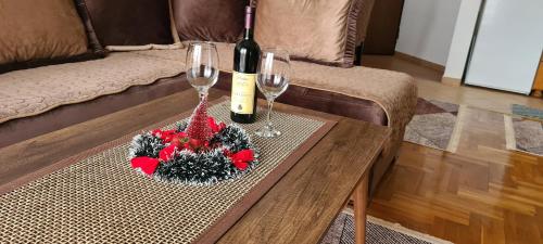 een tafel met twee glazen en een fles wijn bij Apartman Velimir Stari Aerodrom in Svijetin Brijeg
