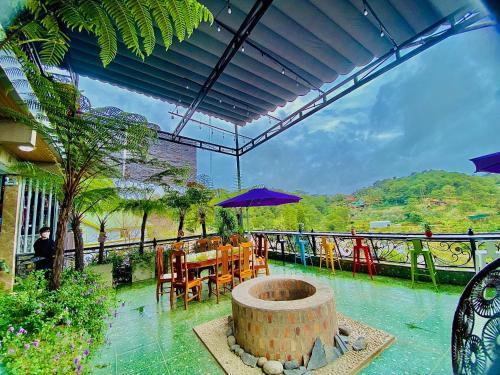 een patio met een tafel en stoelen en een parasol bij Pine Forest House Dalat in Xuan An