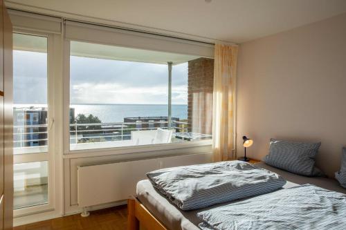 1 dormitorio con cama y ventana grande en Ferienwohnung Wattkönig en Wyk auf Föhr