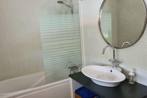 une salle de bain avec un lavabo, un miroir et une baignoire dans l'établissement Maison entre Bordeaux et l'eau, à Pessac