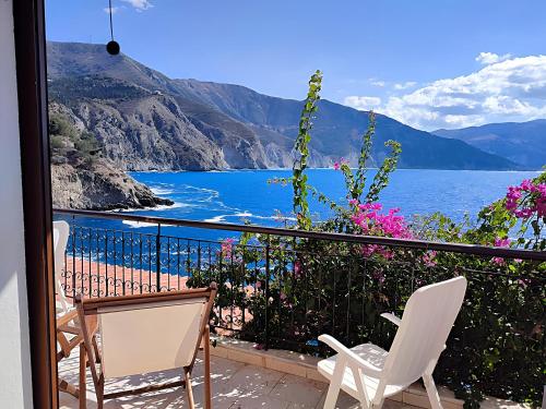 a balcony with chairs and a view of the water at Panorama Apartments in Asos