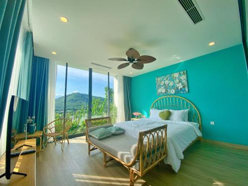 een blauwe slaapkamer met een bed en een groot raam bij Villa 3 bedrooms Venus resort by Flamingo F12 or F24 in Thanh Cao