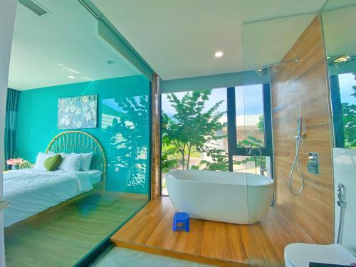 een badkamer met een bad, een bed en een raam bij Villa 3 bedrooms Venus resort by Flamingo F12 or F24 in Thanh Cao