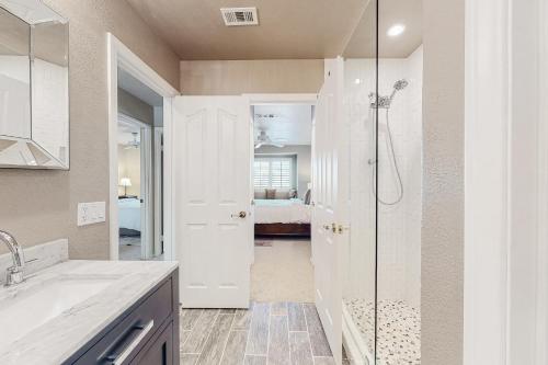 uma casa de banho com um chuveiro e um lavatório. em Carlotta Haven em Palm Desert
