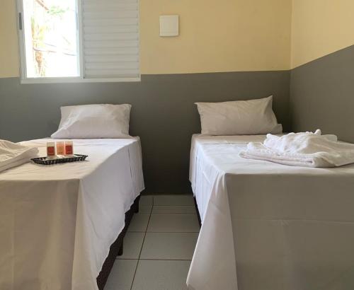 two beds sitting next to each other in a room at Hotel Barão Ribeirão in Ribeirão Preto