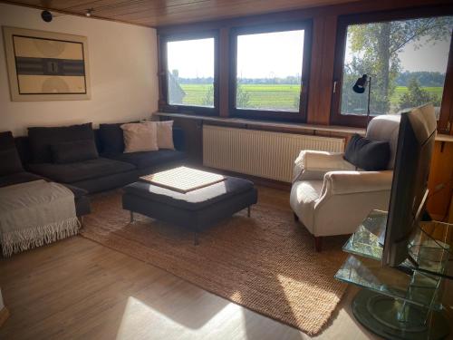 a living room with a couch and chairs and windows at In der Natur gelegene Wohnung mit Weitblick in Hüthum