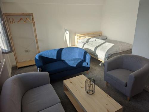 a living room with a couch and chairs and a table at Flat with great transport links in Welling