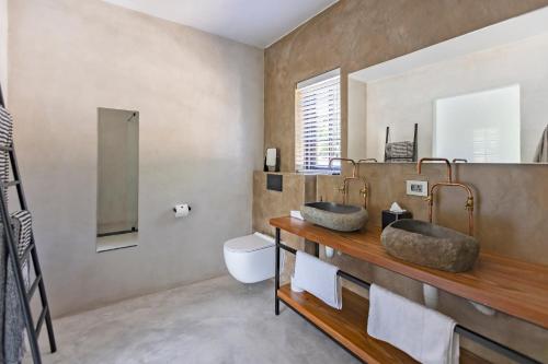 サマーセット・ウェストにあるAfrica Lodgeのバスルーム(洗面台2台、トイレ付)