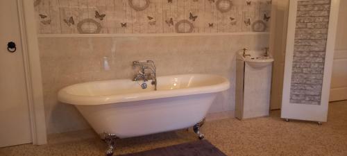 La salle de bains est pourvue d'une baignoire et d'un lavabo. dans l'établissement Butterflies Rest, à Draperstown